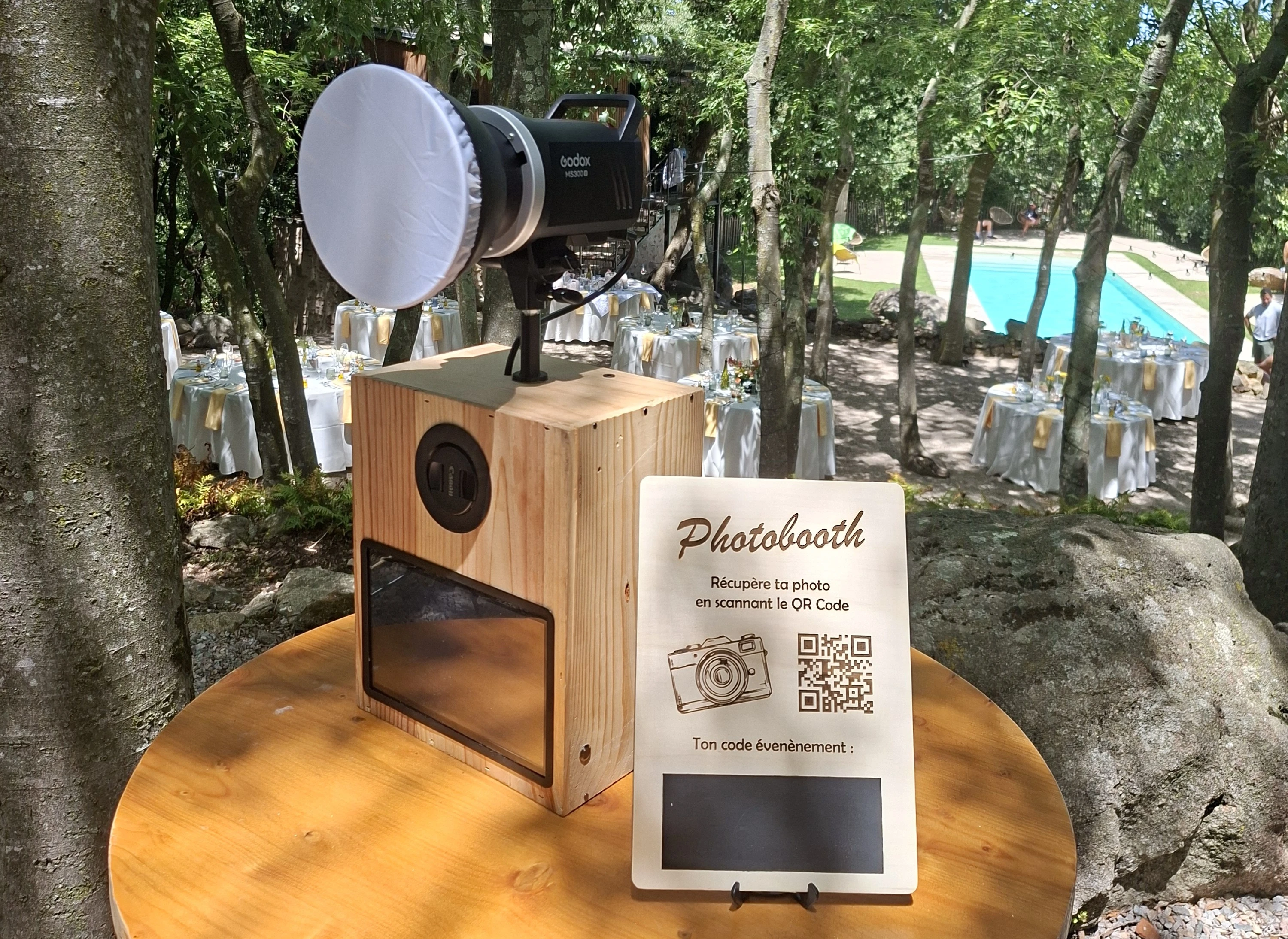 Photobooth at an outdoor event, with a QR sign for guests to retrieve their photos