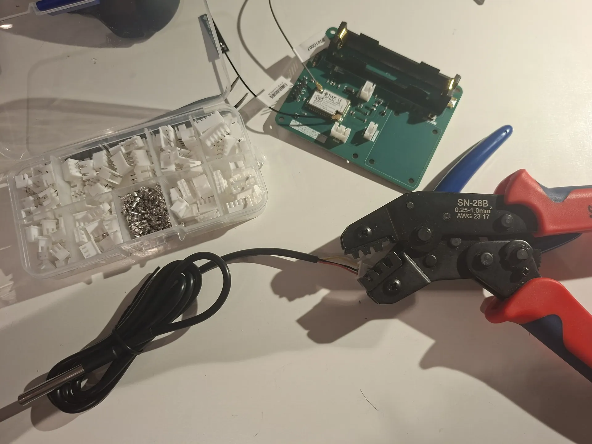 Crimping a JST on the DS18B20 next to the assembled PoolSensor PCB
