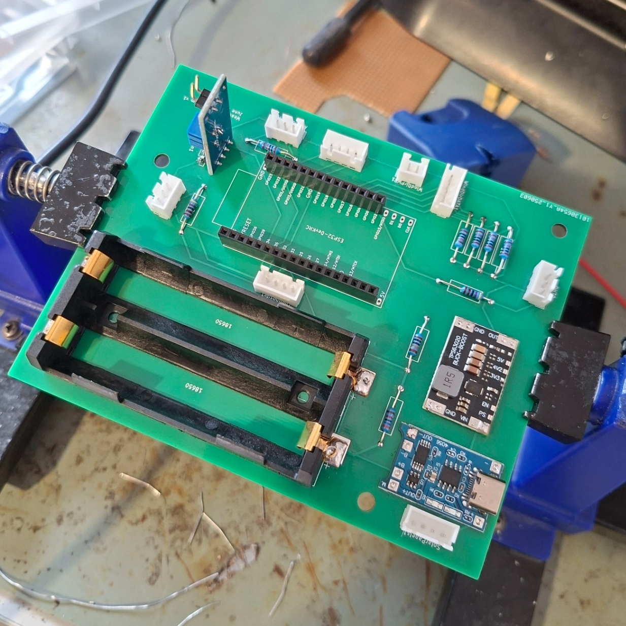 Assembled carrier PCB in a vice, DevKit sockets and 18650 holder